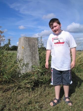 Liam, in his Pirate BBC Essex T-shirt, by the trig point in Bradfield