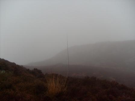 The mound behind the pole looks enormous in the mist, but is only a few feet high!