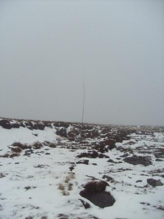 SOTA pole on the snowy moorland summit