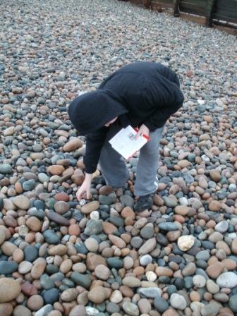 Liam selects a pebble to carry from St Bees